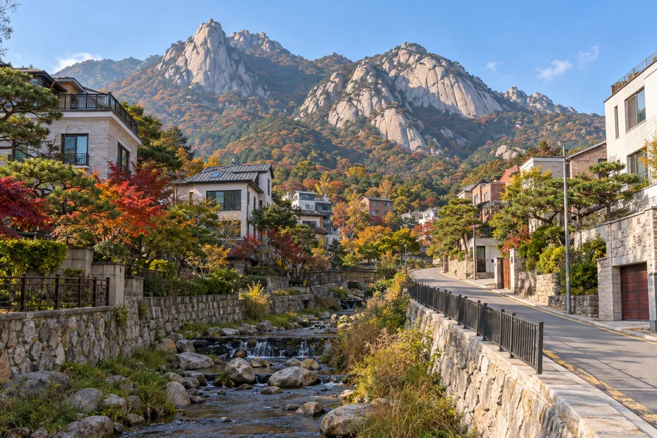 큰 바위산 아래 개울을 따라 들어선 빌라와 주택
